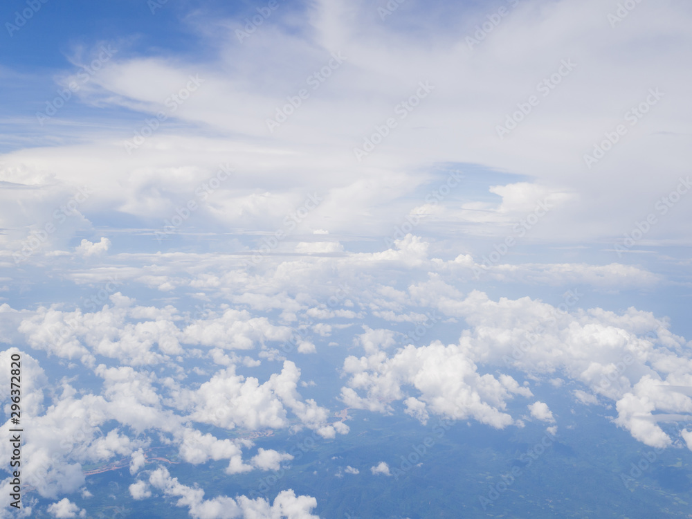 Fototapeta premium Clouds from airplane window with blue sky and high angle ground