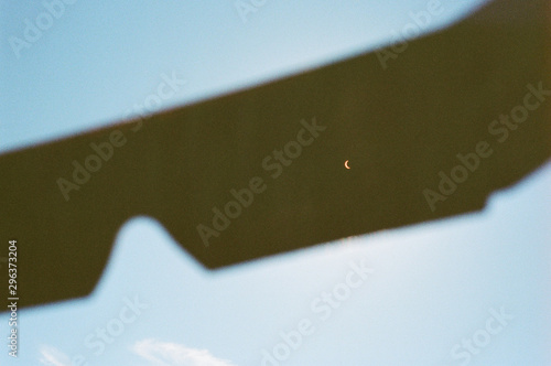 Moon on silhouette object against blue sky