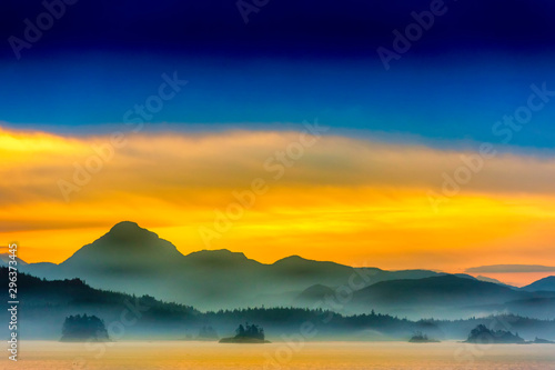 Silhouetted Mountains at Sunset over Ocean © Mark