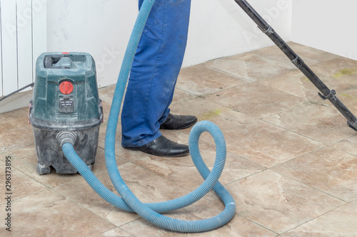 the man vacuums the tile after laying. preparation for jointing