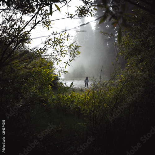 Woman walking by lake in forest
