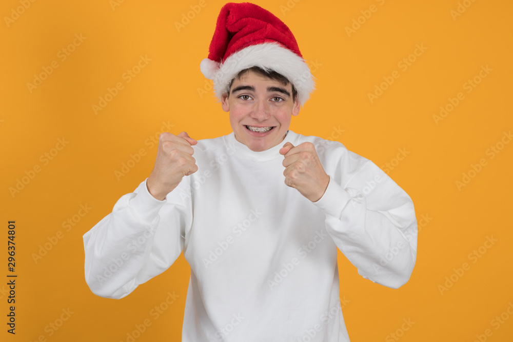 young teenage man wearing santa claus hat and color background young teenage man wearing santa claus hat and color background