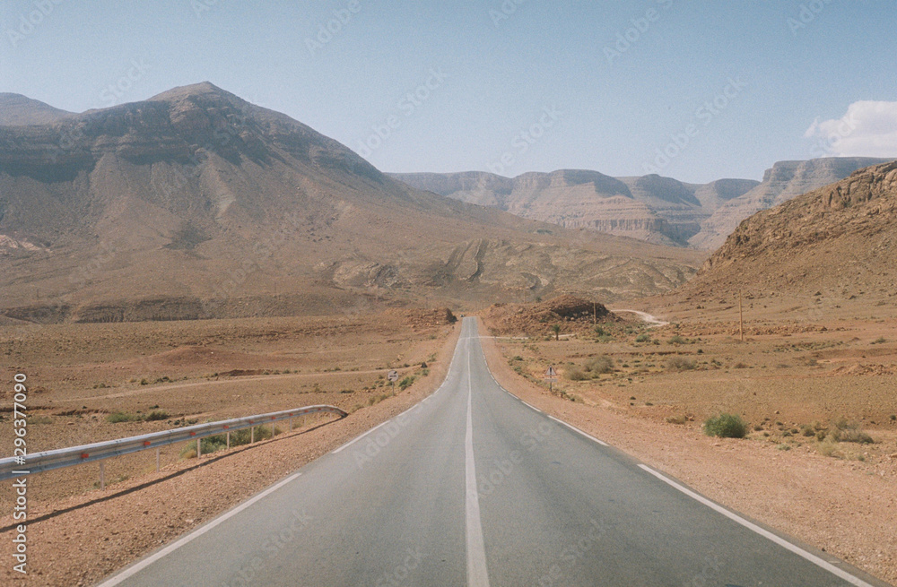 View of empty desert road by mountains, Morocco View of empty desert road by mountains, Morocco