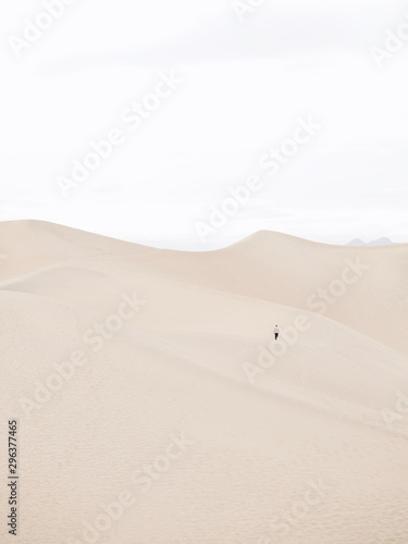 Man walking on sand dune