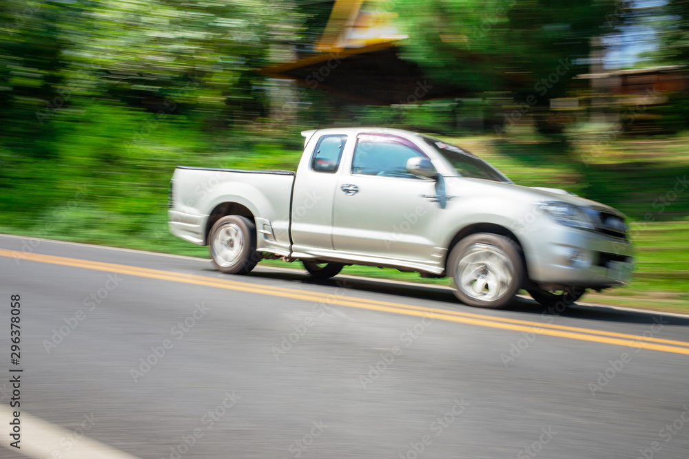 Blurry speedy movement of pickup truck driving on road