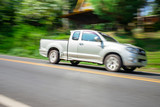 Blurry speedy movement of pickup truck driving on road