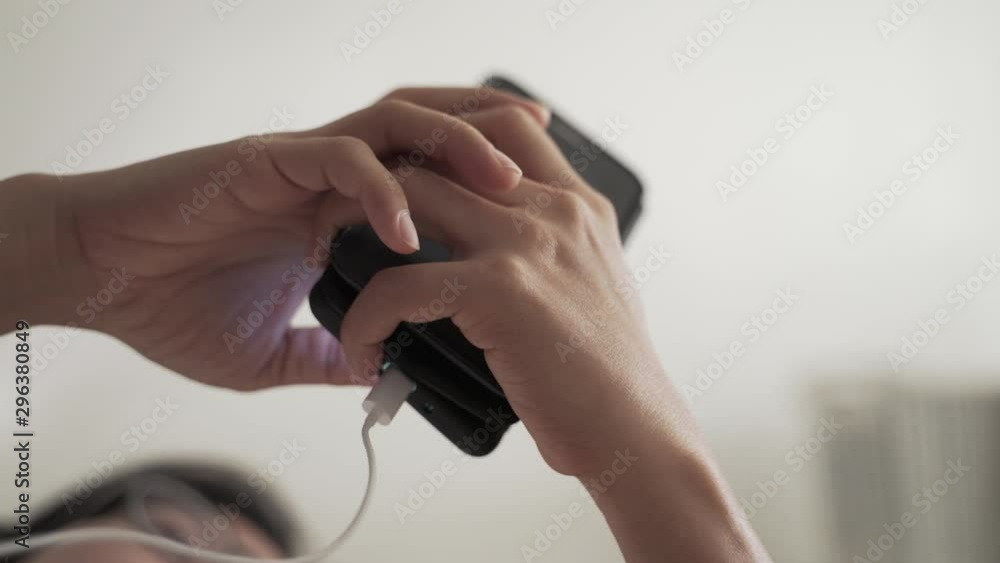 Woman using mobile phone while charging, dangerous and harmful concept Woman using mobile phone while charging, dangerous and harmful concept