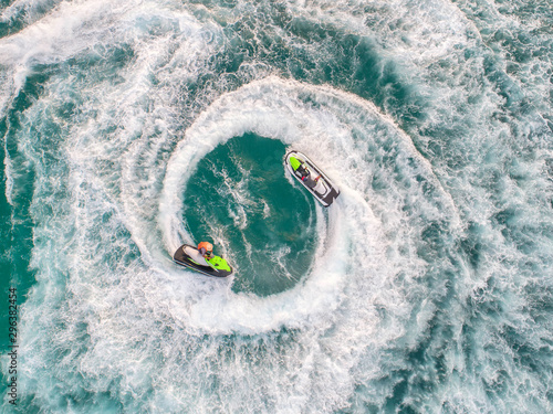 People are playing a jet ski in the sea.Aerial view. Top view.amazing nature background. © MAGNIFIER