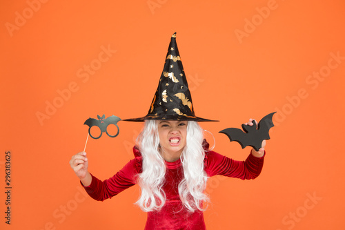 Photo booth props. Small girl in black witch hat. Autumn holiday. Join celebration. Little child in witch costume. Magical spell. Small witch with white hair. Wizard or magician. Halloween party © be free