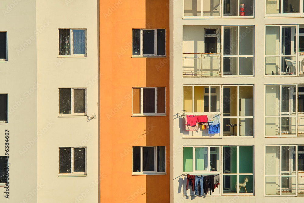 Obraz premium New building. Colorful clothes are hung on the balconies. close-up