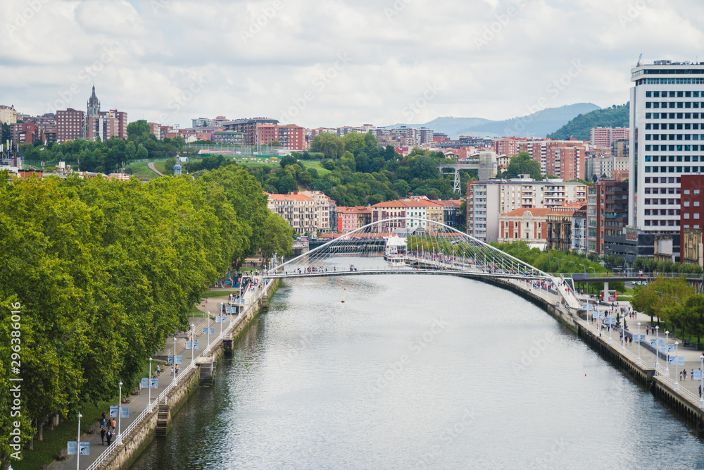 Bilbao, Spain - August 15 2019: View of the buildings in Bilbao by the river, on a cloudy day, beautiful destination in Basque county