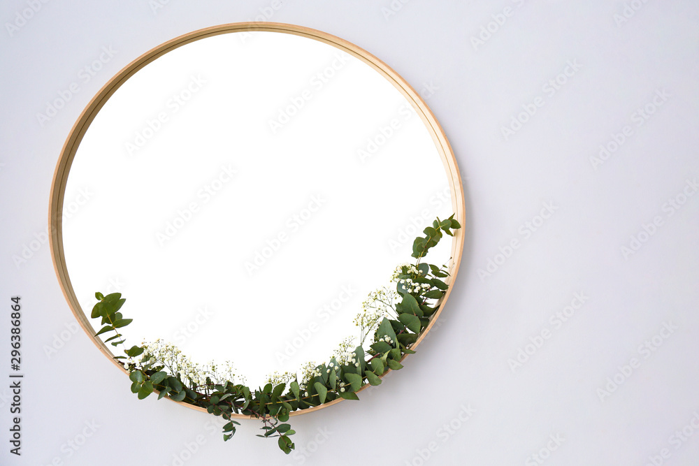 New round mirror in wooden frame on white wall, space for text. Idea for interior design New round mirror in wooden frame on white wall, space for text. Idea for interior design