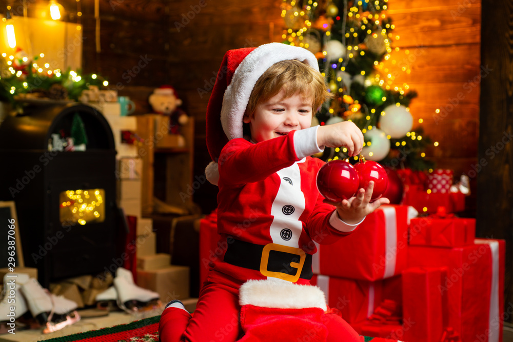 Gifts for winter holidays at fire place. Little boy with Christmas presents. Joy and happiness. Childhood moments. Child cheerful face got gift at christmas. Check contents of christmas stocking.