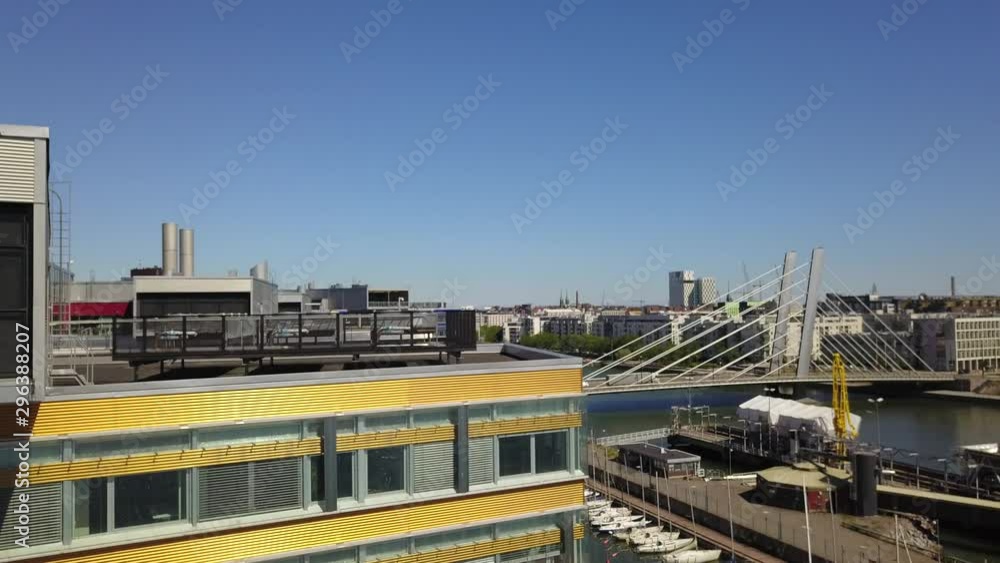 Aerial view of modern colorful building in Helsinki. The camera takes off above the building, behind the building open view the canal Ruoholahti and the bridge. Aerial view of modern colorful building in Helsinki. The camera takes off above the building, behind the building open view the canal Ruoholahti and the bridge.
