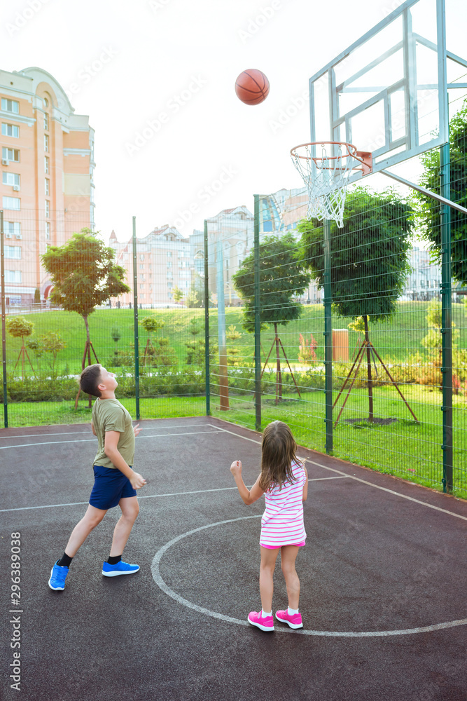 Children play basketball on a city playground. Streetball basketball game  with two players. Stock Photo | Adobe Stock