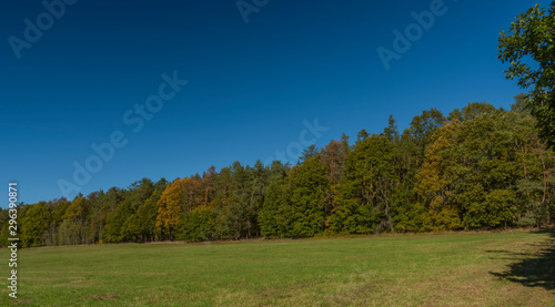 Color autumn meadow and forests with blue sky in Kokorinsko area in Bohemia