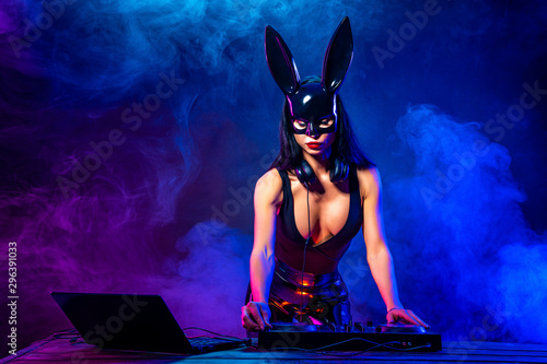 Fotografie, Obraz Young sexy woman dj playing music in mask