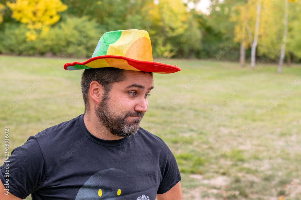 boy with gay pride day hat making a doubtful face with a beard boy with gay pride day hat making a doubtful face with a beard