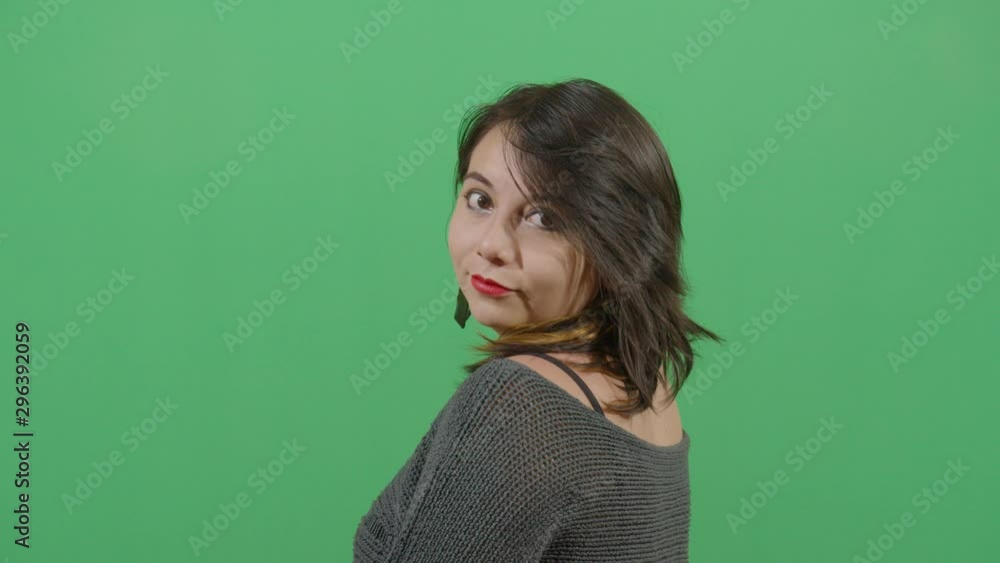 Woman Turning Around To See The Viewer Disclosing His Or Her Identity. Studio Isolated Shot Against Green Screen Background Woman Turning Around To See The Viewer Disclosing His Or Her Identity. Studio Isolated Shot Against Green Screen Background