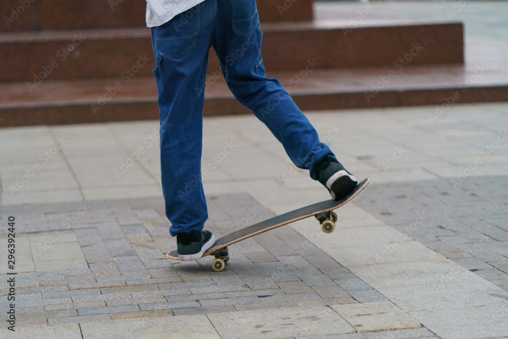 Young skateboarder performs a trick on a city street in autumn day. Young man is jumping. Extreme sports is very popular among youth. Young skateboarder performs a trick on a city street in autumn day. Young man is jumping. Extreme sports is very popular among youth.