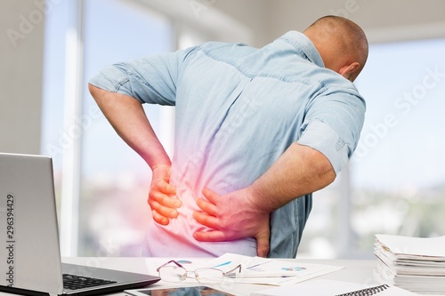 Business man with back pain an office . Pain relief concept