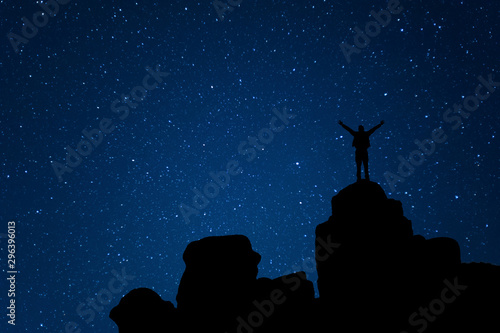 Man on mountain peak view of night sky