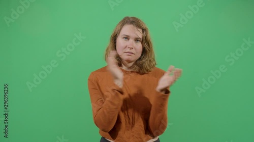 Woman Clapping Slowly Disappointed And Unimpressed. Studio Isolated Shot Against Green Screen Background photo