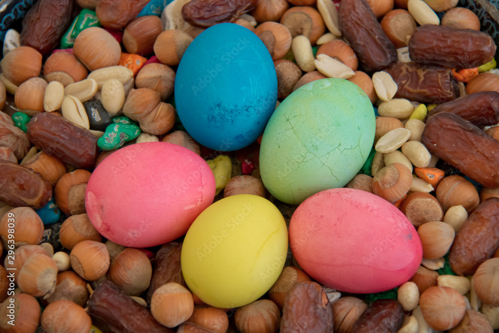 Novruz symbol on xoncha on white background Azerbaijan holiday . There are colored eggs, hazelnuts, dates, and peanuts in the cabin. Novruz symbol on xoncha on white background Azerbaijan holiday . There are colored eggs, hazelnuts, dates, and peanuts in the cabin.