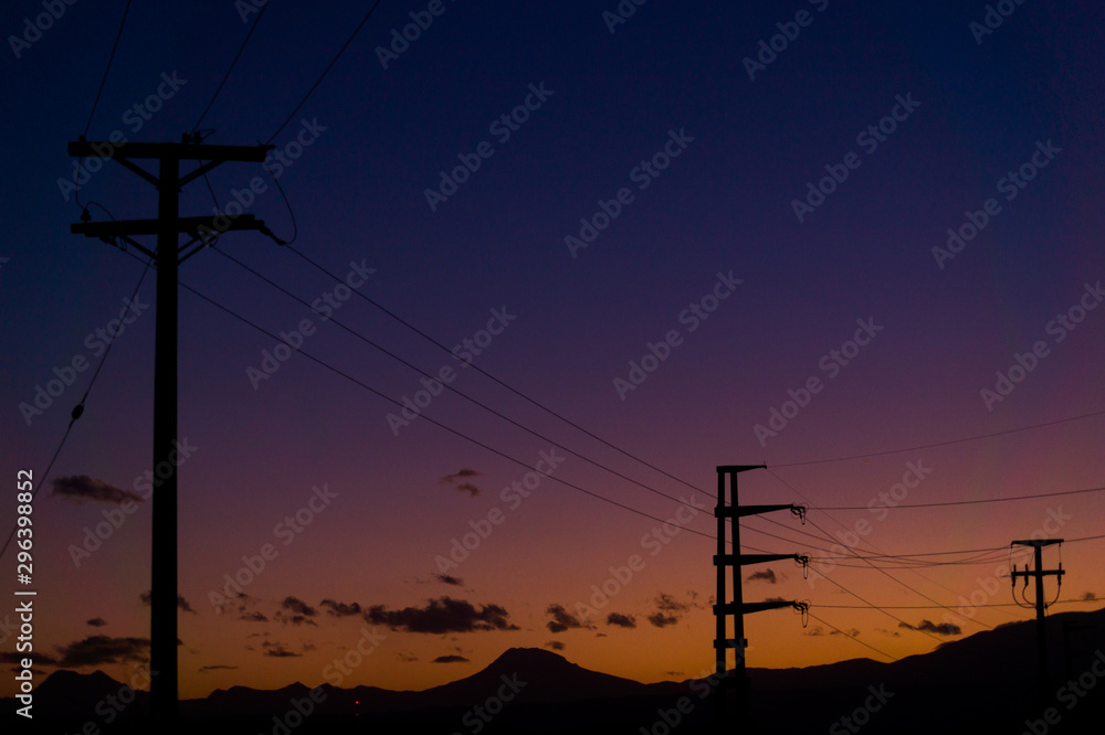 Backlight of electricity lines over a colorful sunset and the background Andes Backlight of electricity lines over a colorful sunset and the background Andes