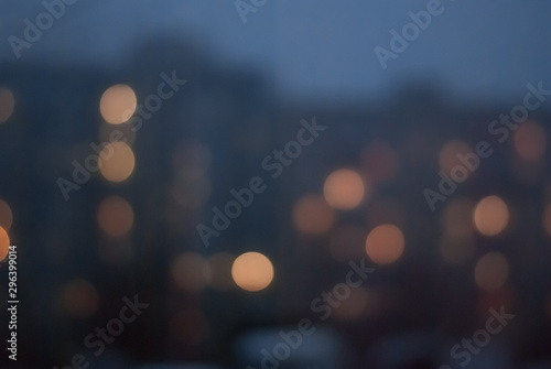 Blurred background of evening cityscape with luminous windows