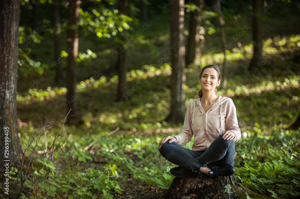Beautiful woman meditating in the forest on a sunny morning Beautiful woman meditating in the forest on a sunny morning