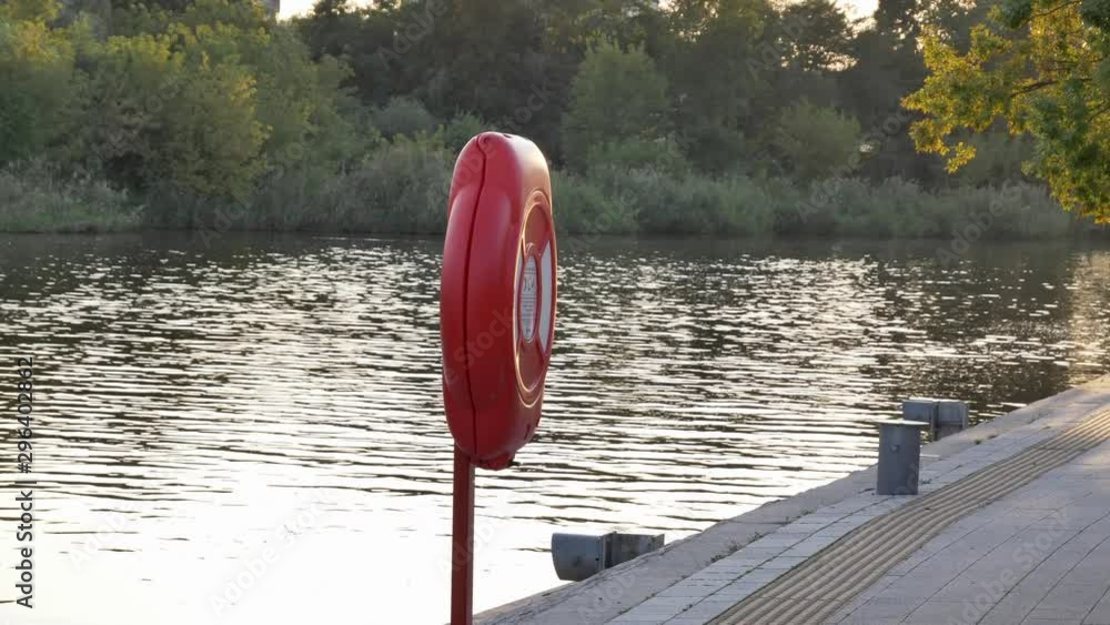 Lifebuoy at quite harbor river marina in summertime sunset or sunrise Lifebuoy at quite harbor river marina in summertime sunset or sunrise