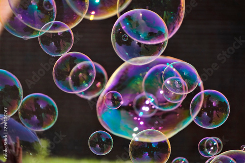 large iridescent soap bubbles of different sizes on the streets of the city. screensaver, copy space, background.