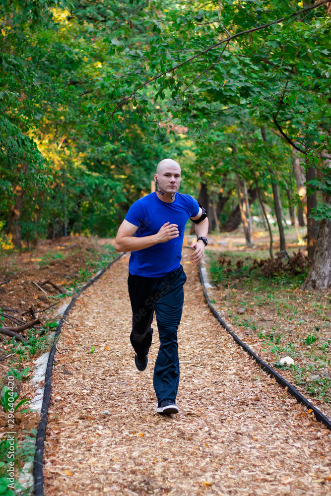 Young man athlete running in the park. Autumn forest leaves. Caucasian male fitness concept. Young man athlete running in the park. Autumn forest leaves. Caucasian male fitness concept.