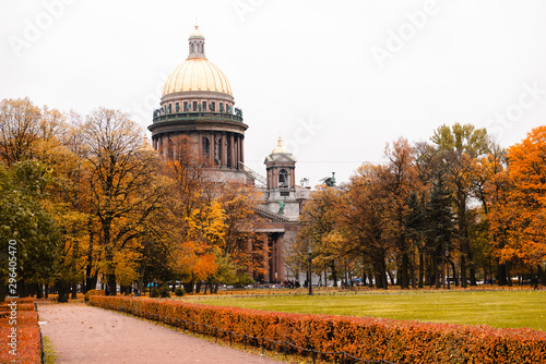 St. Isaac's Cathedral with a Golden dome in St. Petersburg, yellow fallen leaves, path , red autumn bushes,