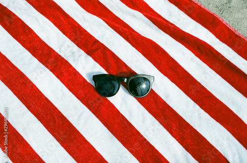 Pair of sunglasses on red and white striped beach towel photo