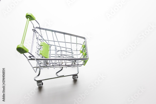 Grocery cart with light green handles on a white isolated background close-up.