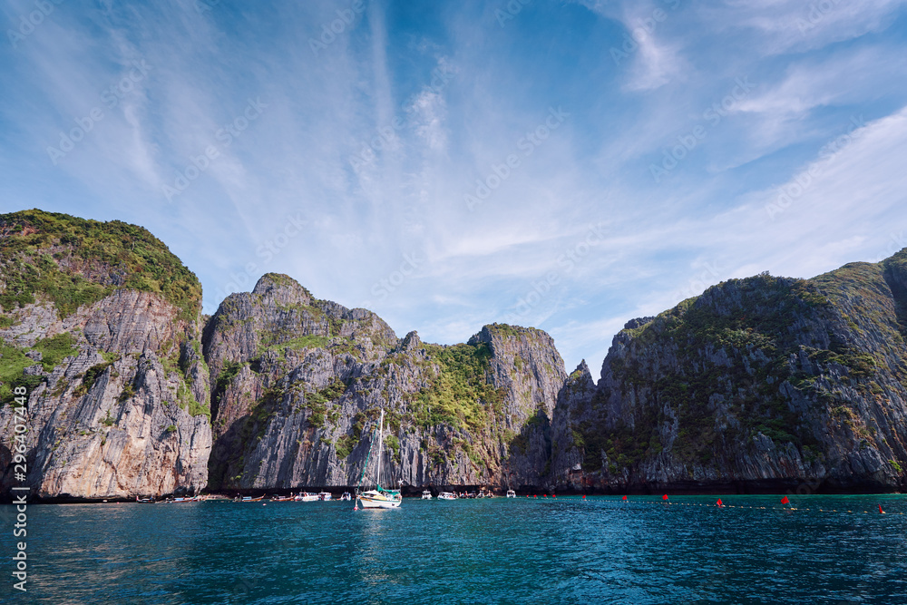 Travel by Thailand. Beautiful tropical lanscape with yacht sailing the sea with famous Maya Bay on the background.