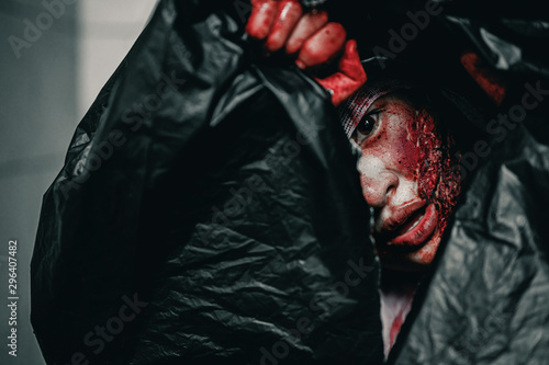 The woman was brutally murdered and put her body resentful and tortured eyes in a bag at abandoned building, Halloween murder concept.