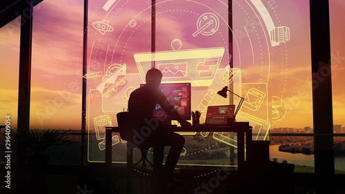 Silhouette of a designer working in his office on the infographics background.