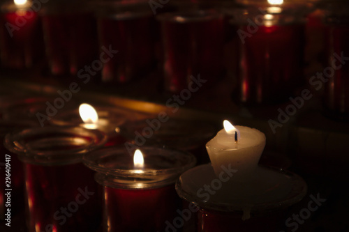 A group of candles in a place to light candles in the church