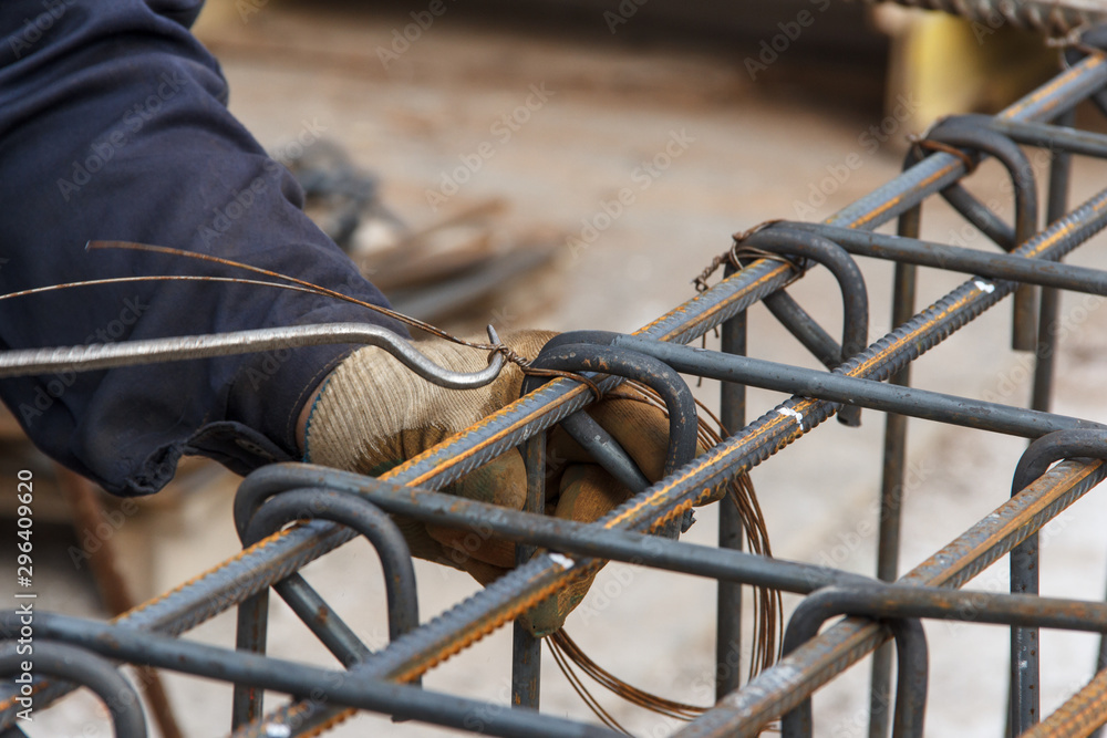 Construction worker fabricating steel reinforcement bars. Preparation for concrete work.