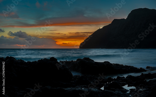 Makapuu lighthouse from Makapuu beach early dawn sunrise with a beacon of light reach out to vessels to safely navigate the straits  photo