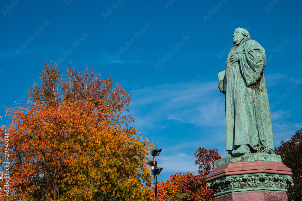 Statue of Martin Luther in Magdeburg downtown in golden Autumn colors and blue sky, Germany