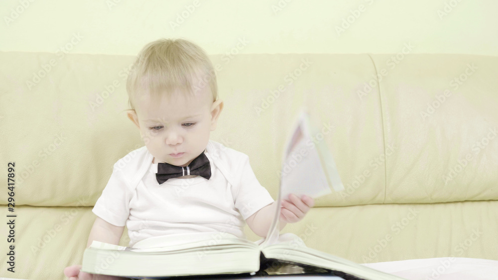 Portrait of funny baby talking, playing with eyeglass and looking in a book Portrait of funny baby talking, playing with eyeglass and looking in a book