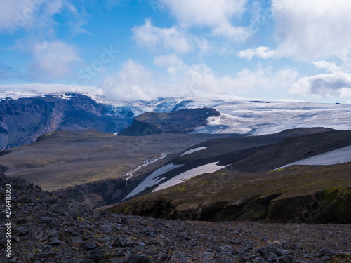 View over a landscape of Godland and thorsmork with the Eyjafjallajokull glacier and volcano, lava formations, snow, ice and green moss. Iceland, Fimmvorduhals hiking trail. Summer cloudy day.