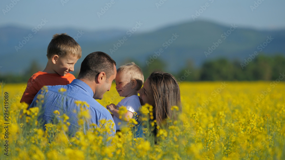Parents with children in yellow rape flowers field Parents with children in yellow rape flowers field