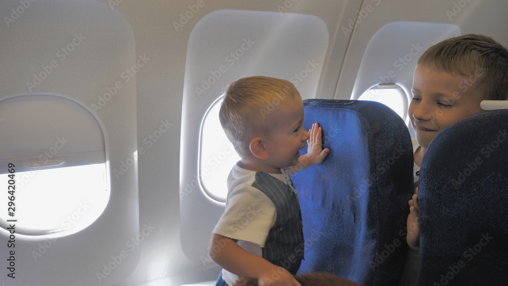 Happy children play in airplane with teddy bear toy, no safe trip