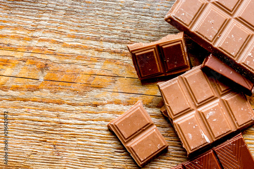 black chocolate pattern on wooden background top view space for text photo