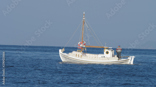 Isolated white boat floating over blue sea water surface © MEDIAIMAG
